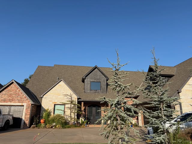 Stone and brick home with dormer windows, recent project